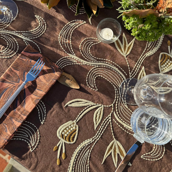 aubergine tablecloth on table with wine classes and place setting